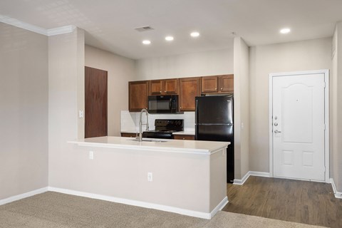 a kitchen with a large island and a black refrigerator
